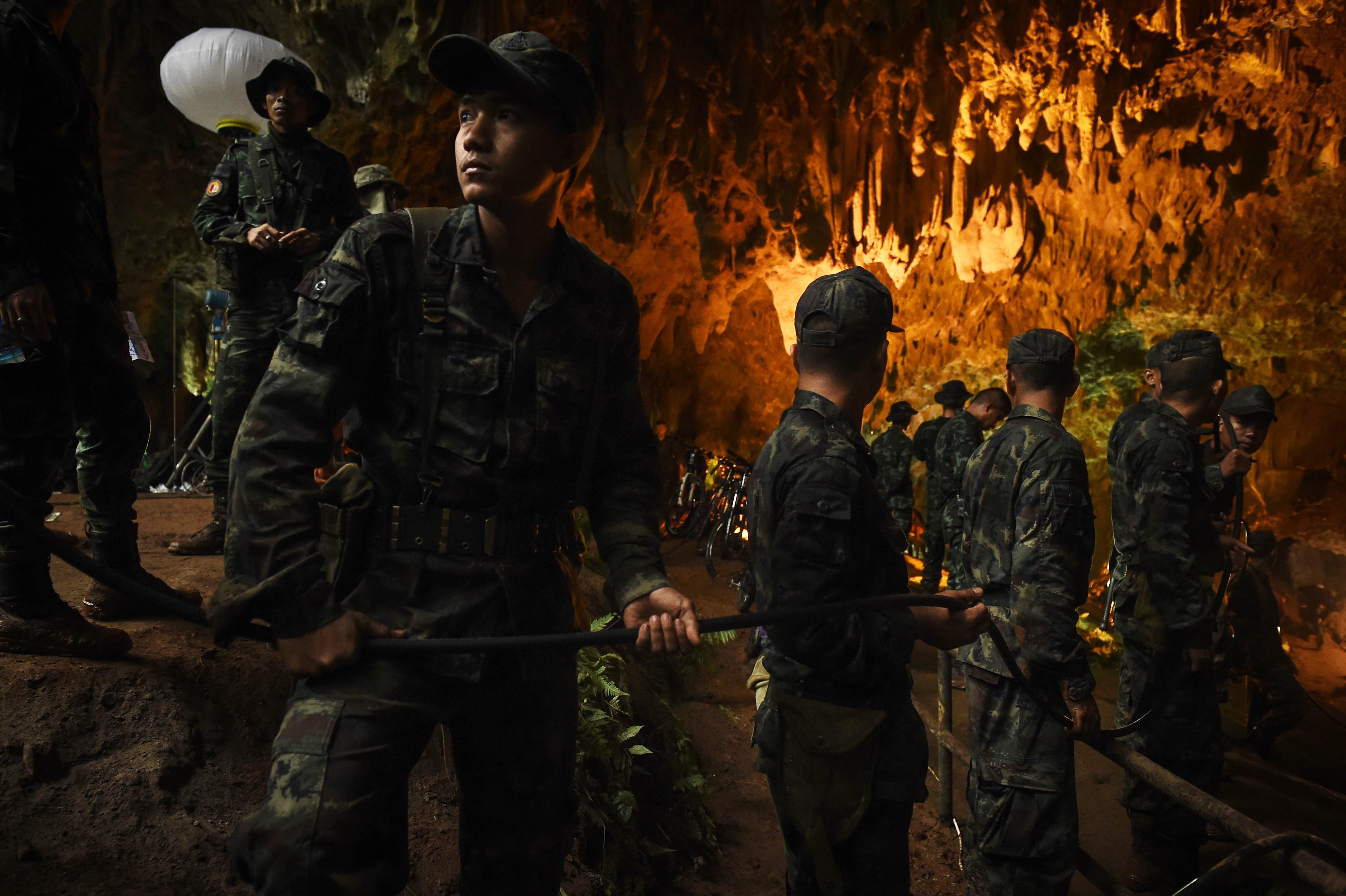 Resgate Na Tailandia Cave 300 027 Thai Cave Rescue Soldier Holding Cable In Lit Cave Gettyimages 984233480 Discovery Estreia «Resgate Na Tailândia». Documentário Sobre O Salvamento Das Crianças E Treinador